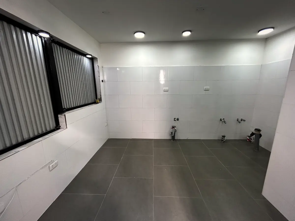 Cocina terminada con cerámica blanca y piso porcelanato